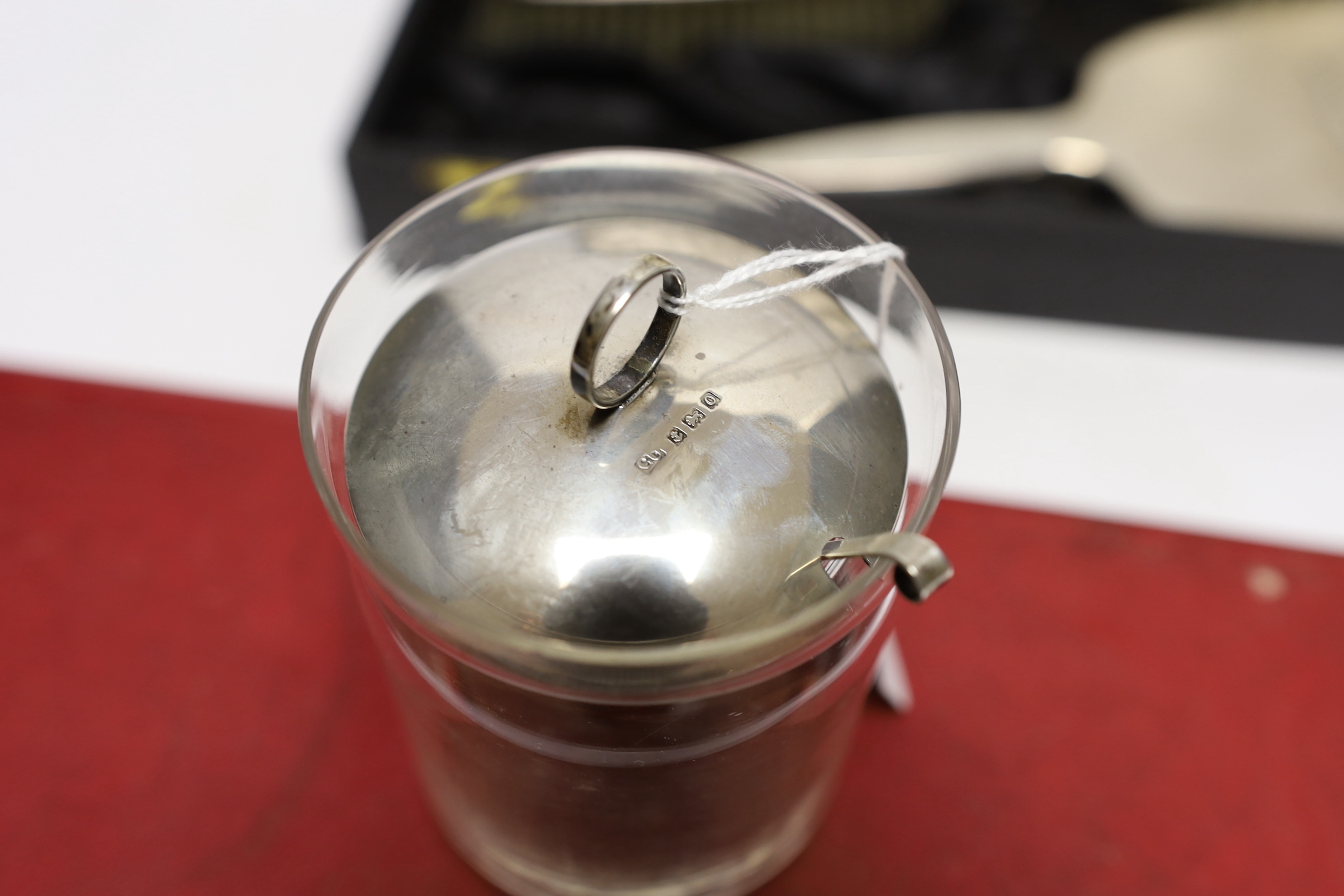 An Elizabeth II cased silver mounted three piece mirror and brush set, with RAF wings applique, twelve sterling spoons and a silver mounted glass preserve jar.